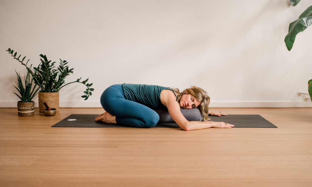 Vrouw in restorative yin houding als somatische oefening