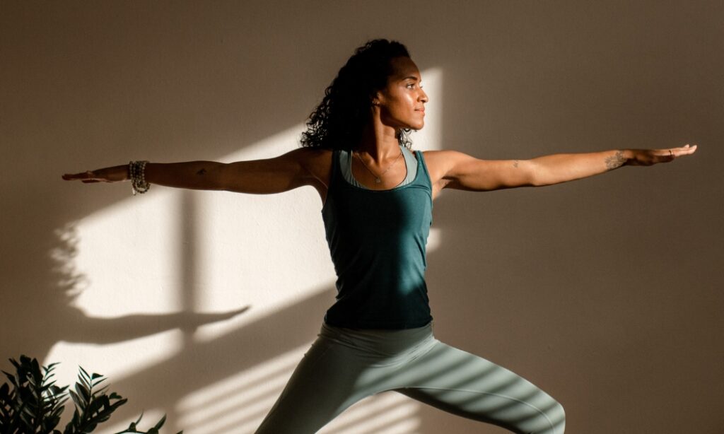 Dame die een yoga pose beoefent in een yogastudio
