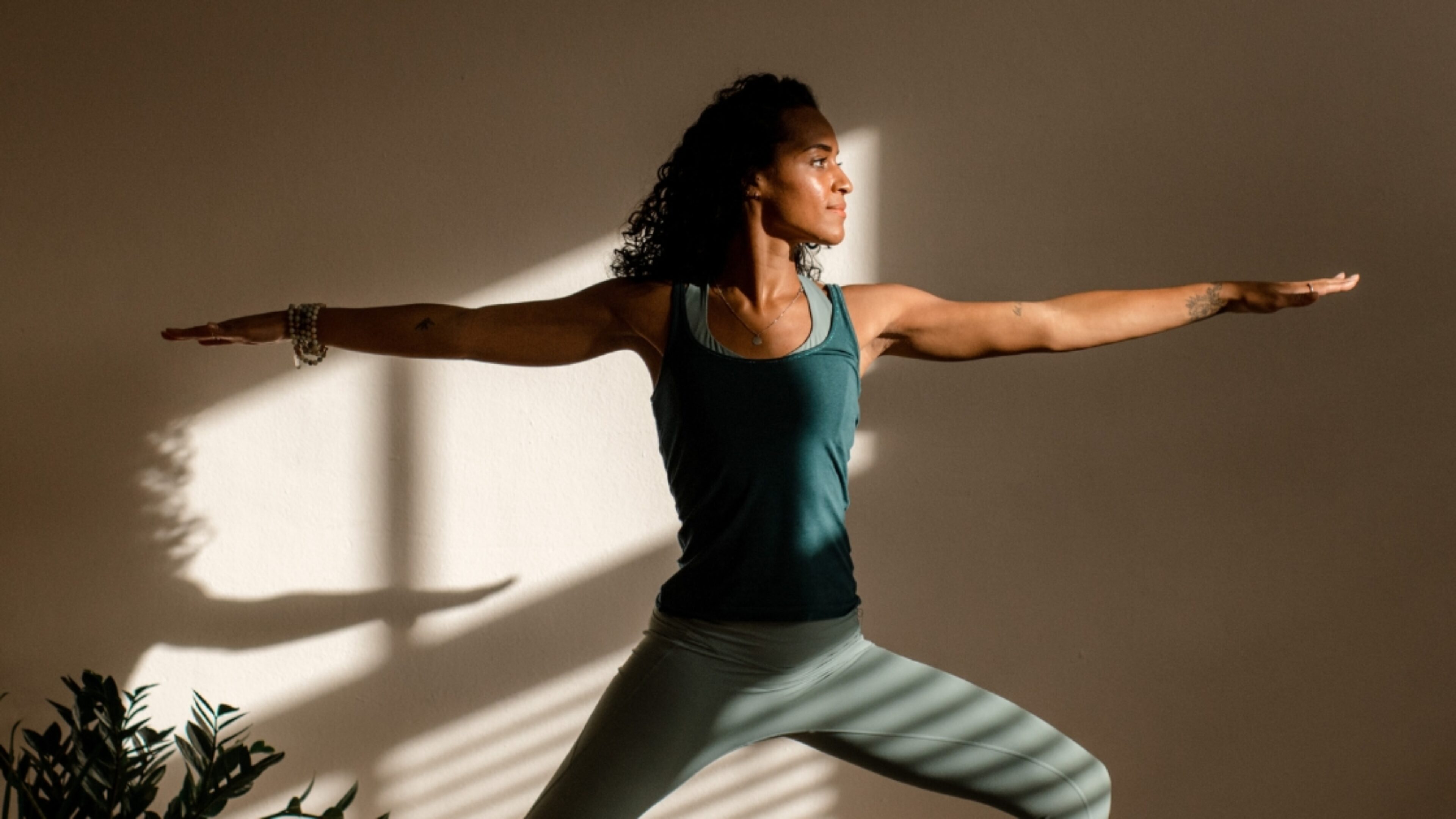 Dame die een yoga pose beoefent in een yogastudio