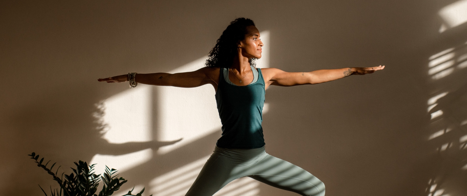 Dame die een yoga pose beoefent in een yogastudio