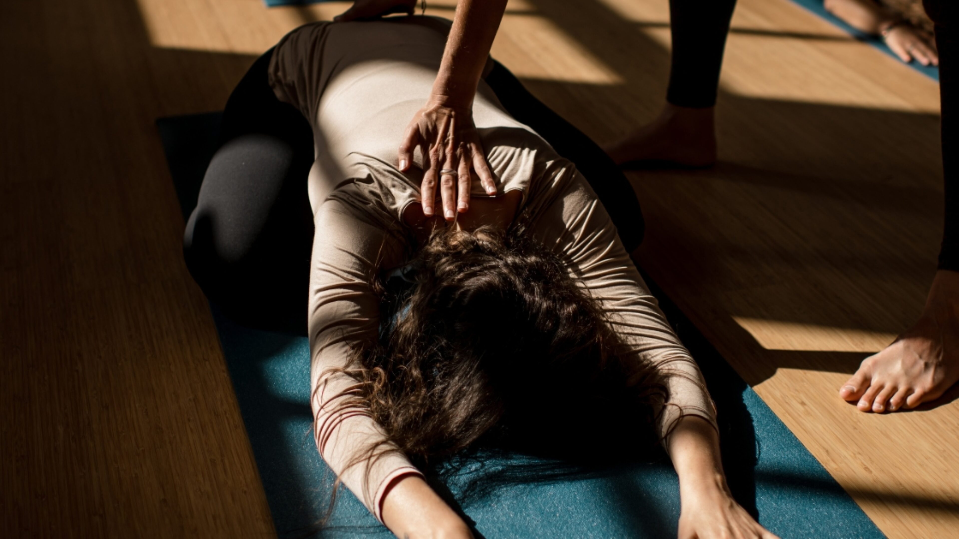 Student in a restorative pose, during a sunny Restorative Yoga session