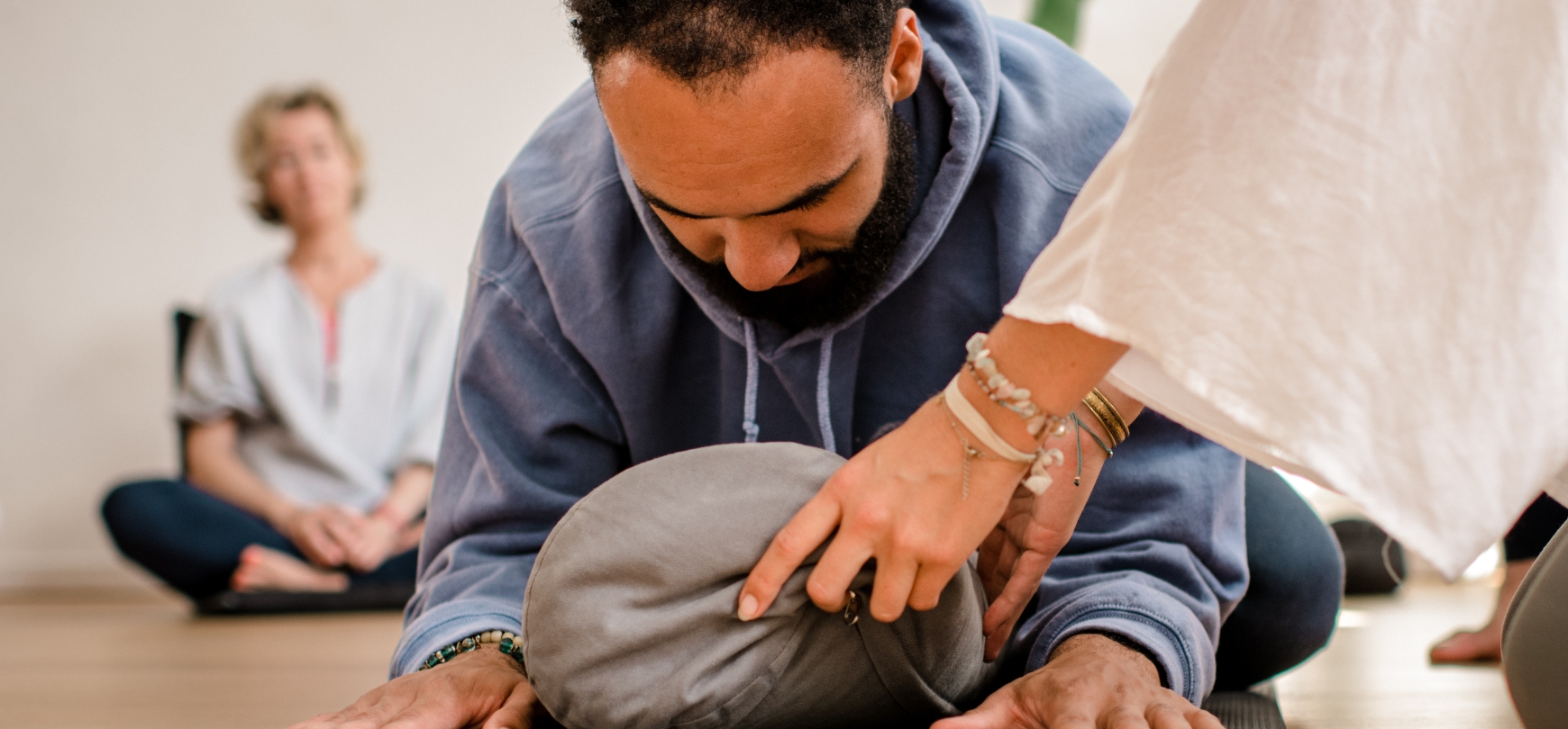 iemand die yoga beoefent met een kussen om zachtheid in de yoga practice te oefenen