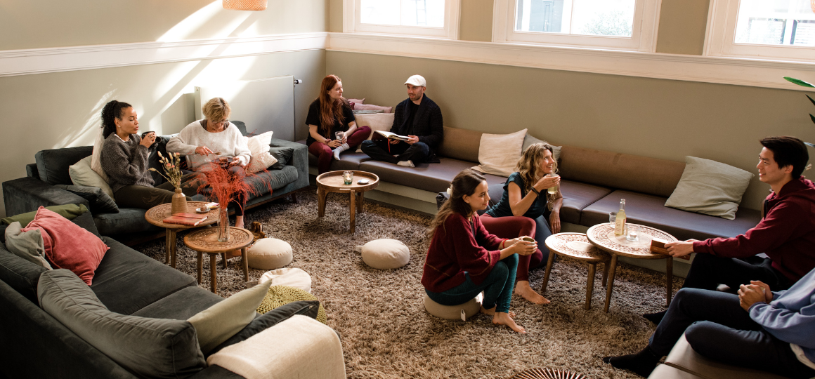 Mensen zitten in het DNYS cafe te praten en te drinken