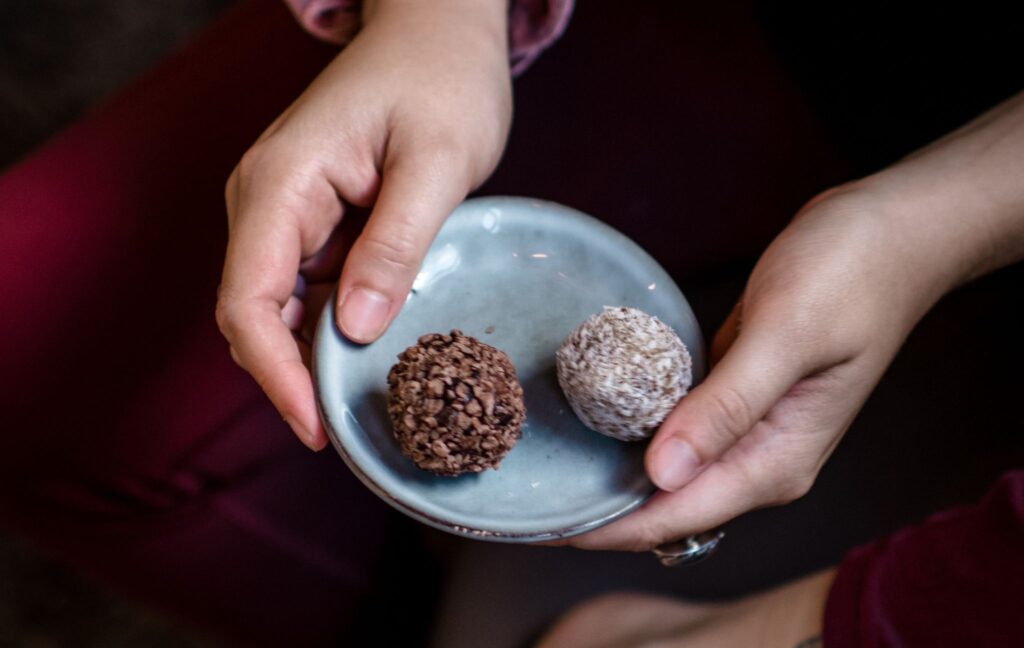 Persoon met een bordje bliss balls.