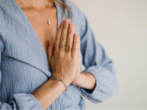 Persoon die handen bij elkaar vouwt in Namasté gebaar