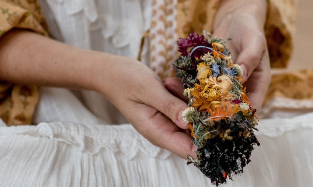 Person holding a flower smudge during a workshop at De Nieuwe Yogaschool in Amsterdam