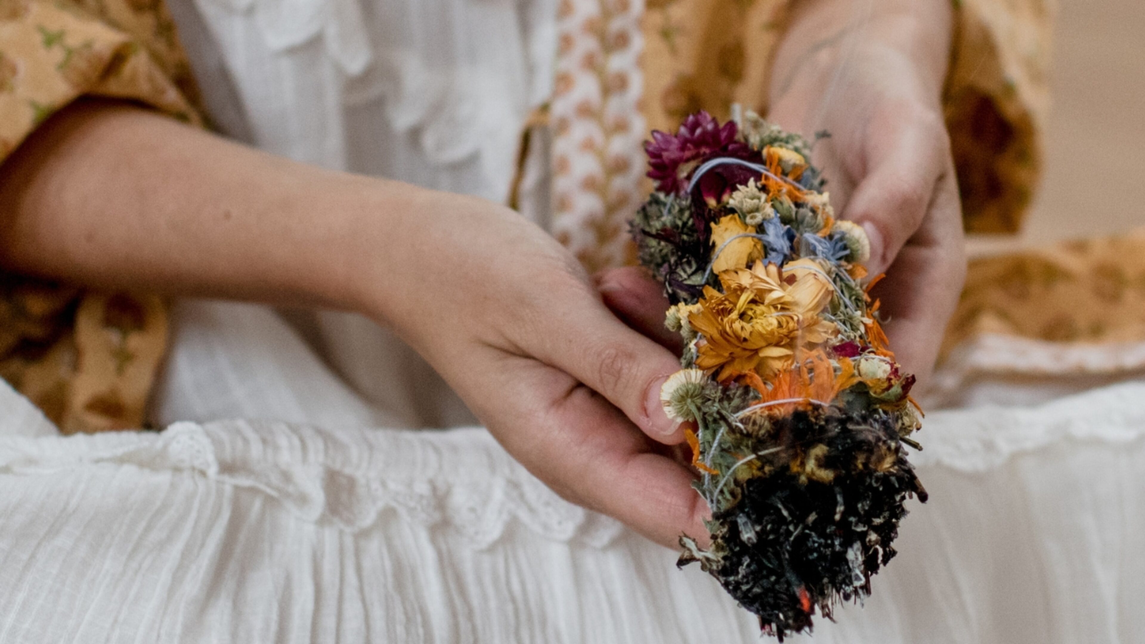 Person holding a flower smudge during a workshop at De Nieuwe Yogaschool in Amsterdam