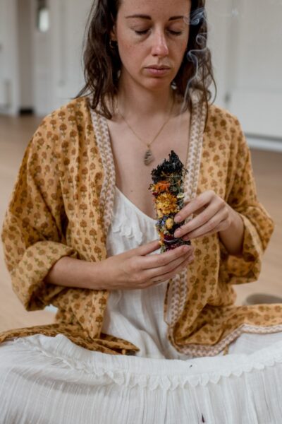 Person holding a flower smudge during a workshop at De Nieuwe Yogaschool in Amsterdam