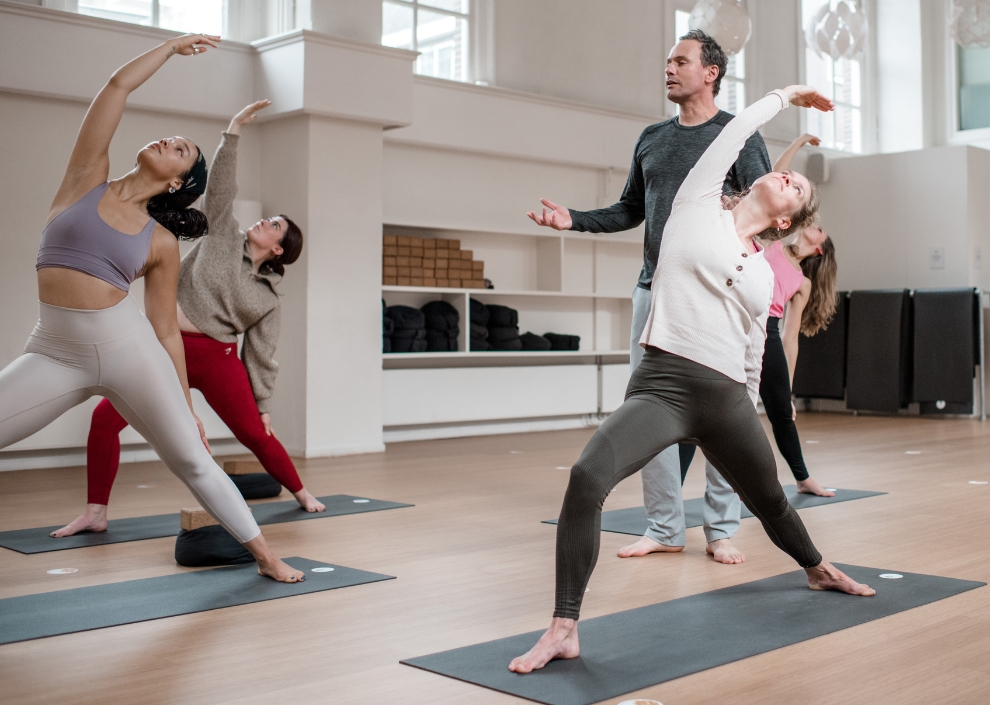 Students in a Vinyasa yoga pose during a class by Johan Noorloos at De Nieuwe Yogaschool