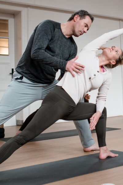 Student in a Vinyasa pose being adjusted by DNYS Academie teacher Johan Noorloos