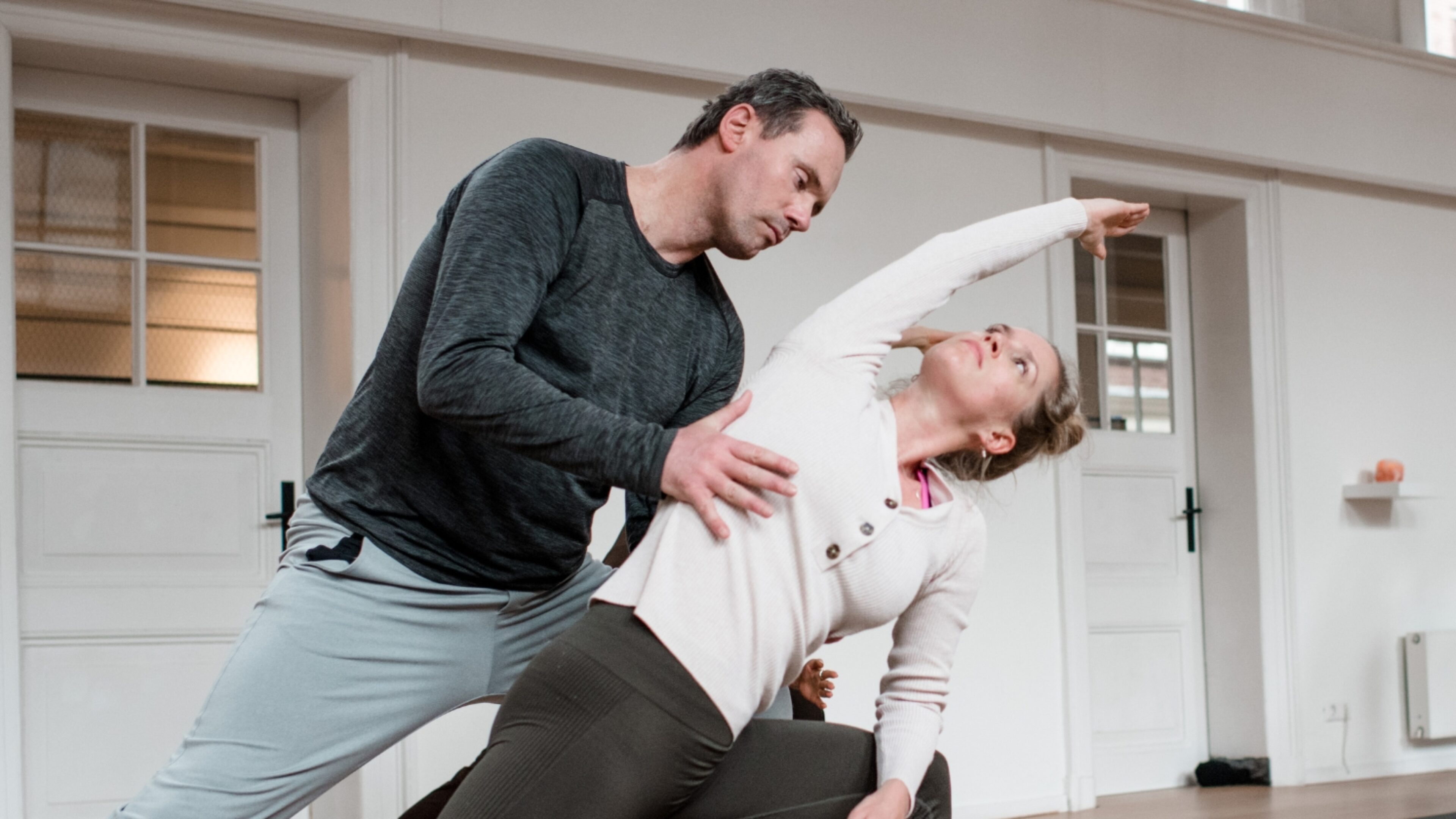 Student in a Vinyasa pose being adjusted by DNYS Academie teacher Johan Noorloos