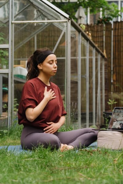 studente in yoga pose tijdens online yogales van De Nieuwe Yogaschool in de tuin