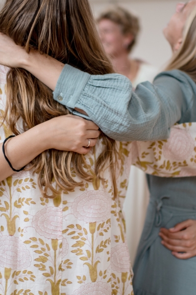 vrouwen die elkaar omhelzen in een cirkel in de studio van De Nieuwe Yogaschool