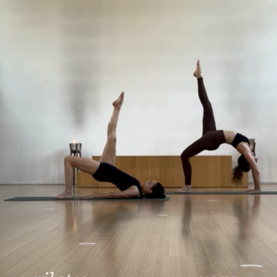twee studenten die enerzijds yoga en pilates beoefenen in de zaal