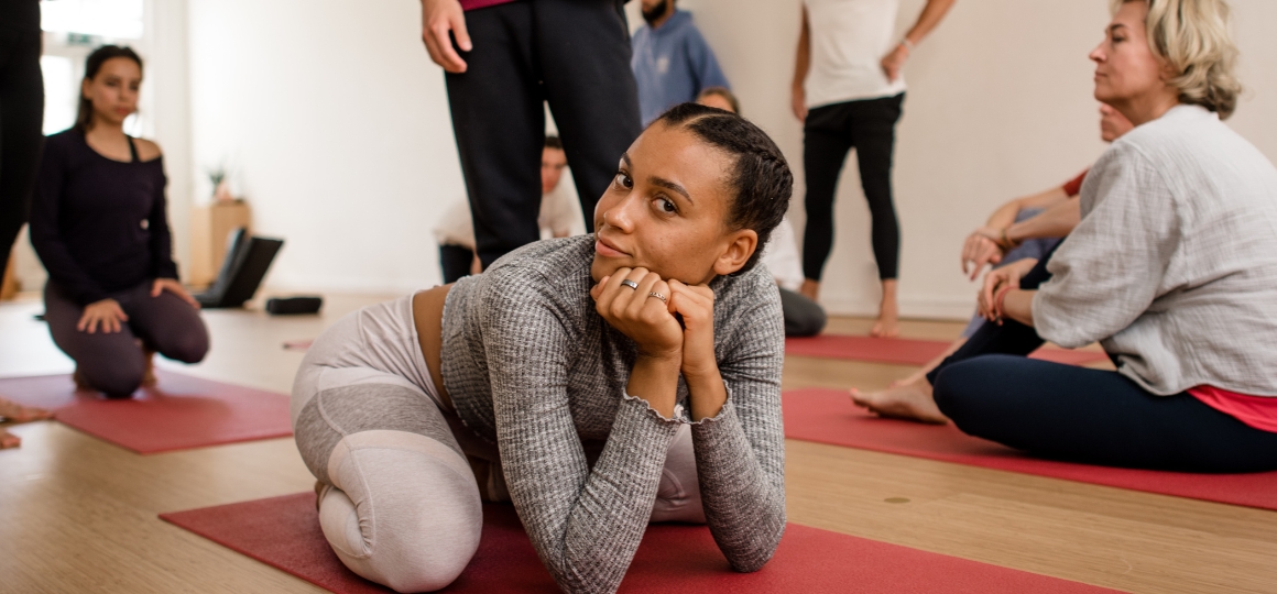 yoga student die in een pose zit en je aankijkt