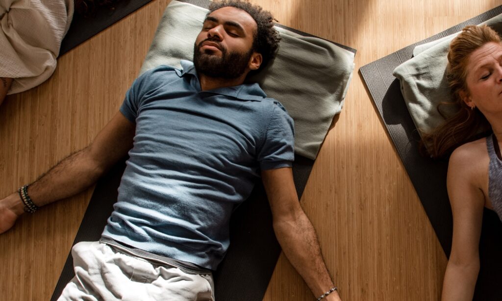 mensen die in een cirkel liggen en een ademoefening doen bij De Nieuwe Yogaschool Amsterdam