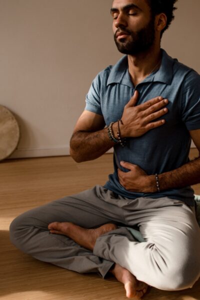 Man die hand op zijn borst en op zijn buik heeft tijdens een ademoefening bij De Nieuwe Yogaschool