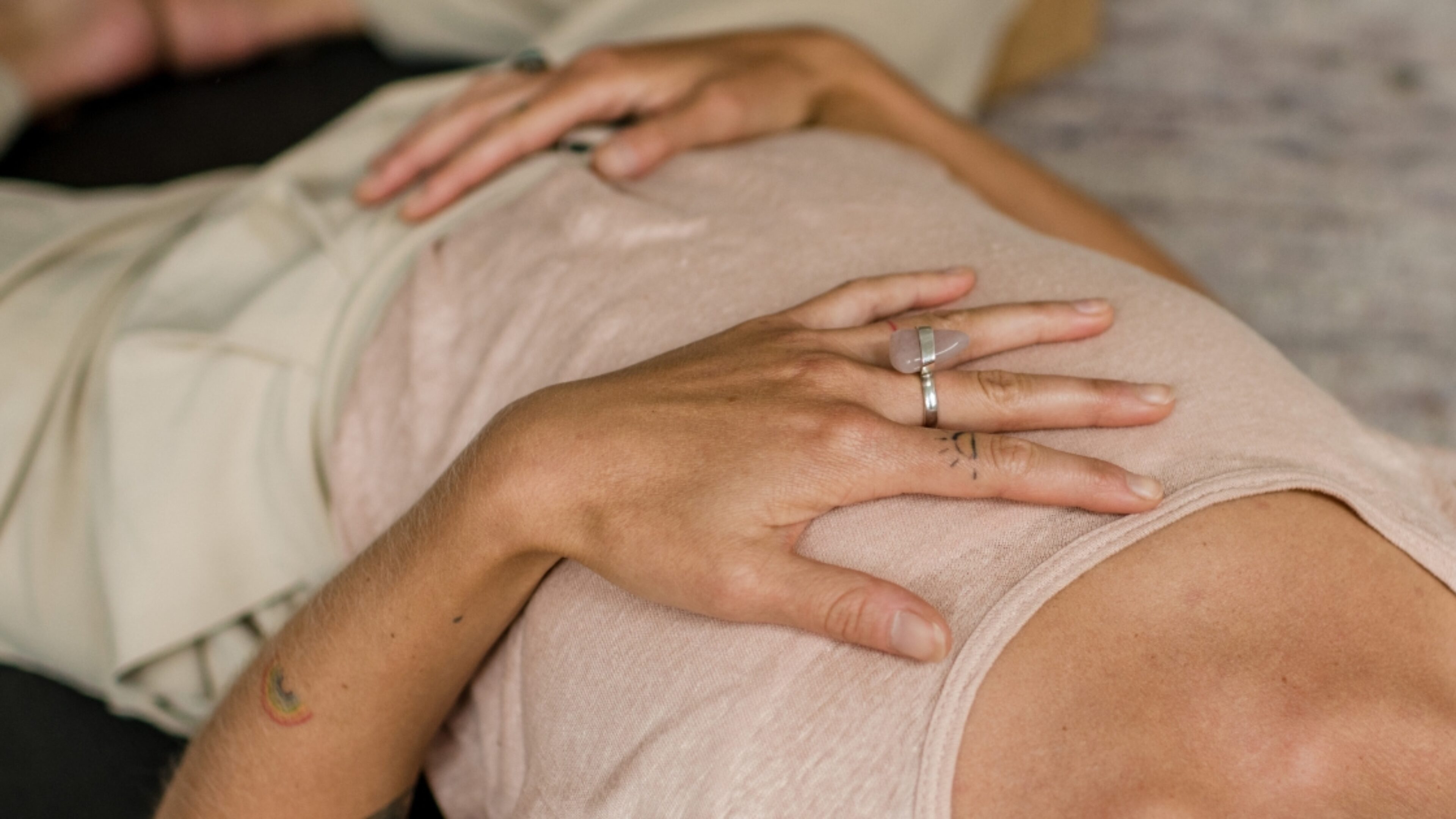 Vrouw die met hand op hart en buik ligt tijdens Yogatherapie opleiding van De Nieuwe Yogaschool